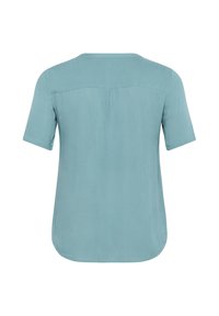 Majica kratkih rukava od mekog, suptilnog teal materijala. Ima okrugli izrez i blago zakrivljen rub s opuštenim krojem.