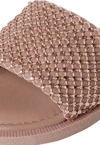 Sandalo rosa pallido con parte superiore texturizzata in rete geometrica e strass decorativi, soletta morbida e suola gommata.