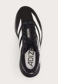 Schwarz-weißer Adidas Adizero Laufschuh mit Schnürsenkeln und Branding auf der Zunge und Innensohle, von oben gesehen.