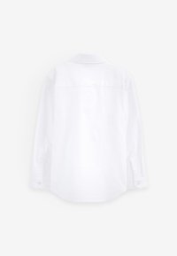 Valge pika varrukaga kraega särk, nähtud tagantpoolt, kinnitatud mansettide ja sirge äärega tavalise valge taustaga.