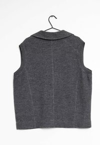 Gilet grigio senza maniche con un ampio colletto, realizzato in tessuto morbido, con dettagli di cucitura sottili e bordi a coste. Appeso a un gancio nero.