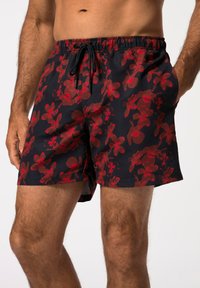Costume da bagno neri con motivo floreale rosso, vita elastica con cordino e tasche laterali. Tessuto leggero con una texture liscia.