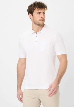 Polo bianco realizzato in tessuto morbido, con una chiusura a tre bottoni, maniche corte e una tasca a toppa sul lato sinistro del petto.