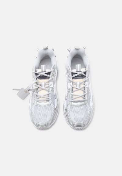 Ζευγάρι λευκά και γκρι αθλητικά παπούτσια με πλέγμα και συνθετικά υλικά, δεμένα με κορδόνια, εμφανιζόμενα από πάνω σε απλό φόντο.