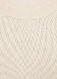 Material tricotat texturat de culoare bej deschis cu guler rotund; prezintă un model în fagure, textură moale și guler rib. 