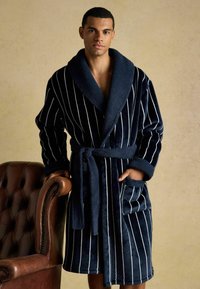 Mörkblå randig badrock med sjalkrage, plyschtextur, vida ärmar och knytbart midjeband, med två framfickor.