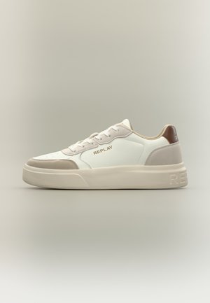 Baskets basses blanches avec accents en daim beige, semelle épaisse et patch marron au talon, avec le logo "REPLAY" sur le côté et la semelle.