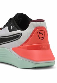 Sorte og hvide sneakers har en tekstureret overdel, en markant koralhælkant og en lysegrøn ydersål med "FUSE" branding på hælen.