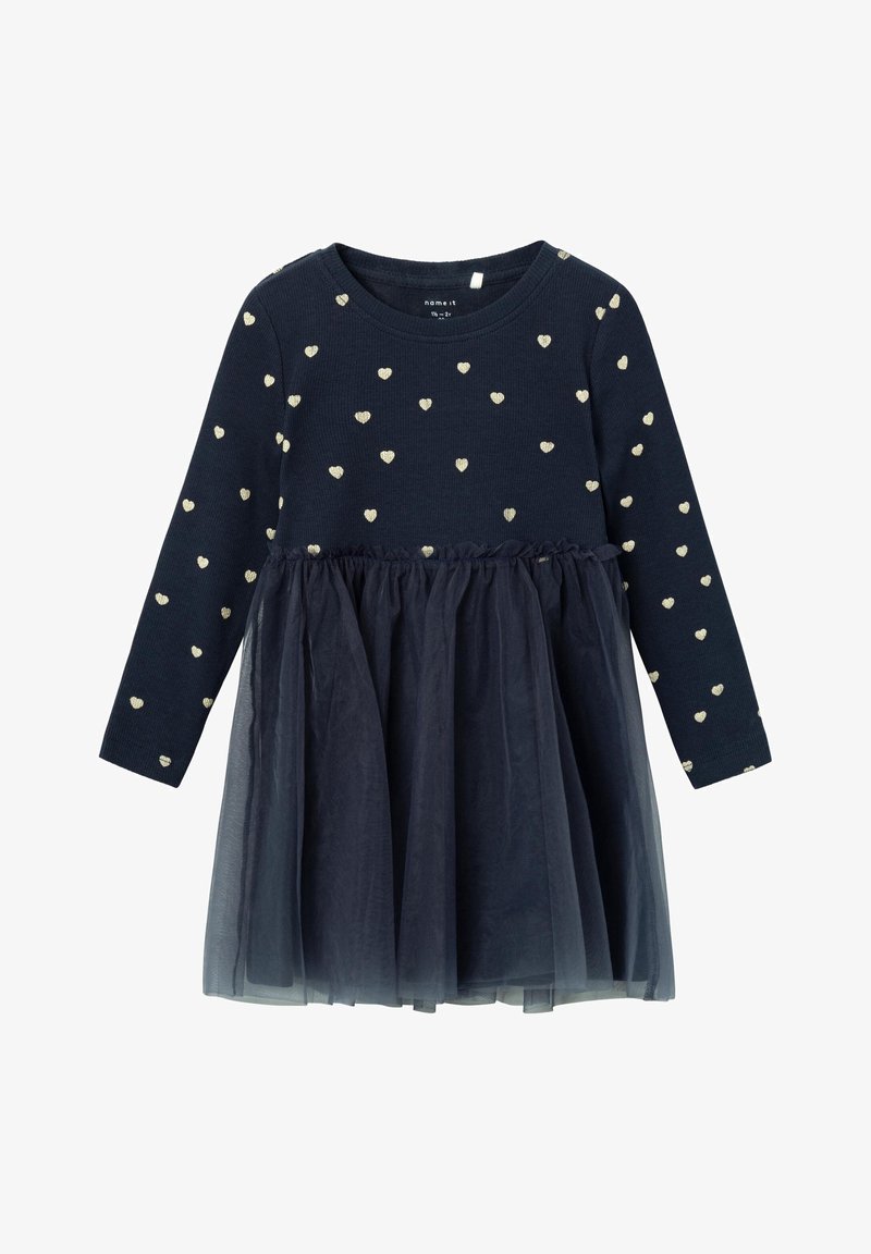 Robe bleu marine à manches longues avec de petits motifs de cœurs blancs sur le haut et une jupe en tulle superposée en bas.