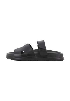 Chanclas negras con dos tiras cruzadas y cierre de velcro ajustable, que cuentan con una plantilla texturizada y suela de goma con patrón antideslizante.