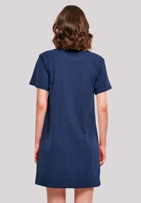 Marineblaue Baumwoll-T-Shirt-Kleid mit kurzen Ärmeln, geradem Schnitt und abgerundetem Saum. Sanfte Textur, minimalistisches Design, keine sichtbaren Verzierungen.