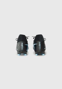 Black soccer cleats with a textured upper, blue accents, and a sleek design. Features a lace closure and pointed studs for traction.