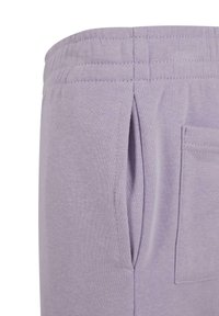 Lilla bomullssvetter med elastisk midjebånd, med sidelommer og en myk tekstur, designet for komfort og uformell bruk.