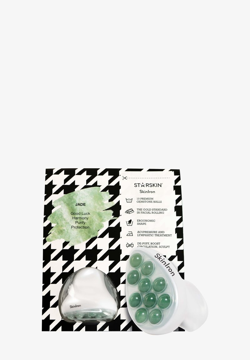 Rouleau de massage facial en jade avec dix pierres précieuses vertes, à côté d’un emballage noir et blanc qui énumère les bienfaits du massage et des soins de la peau.