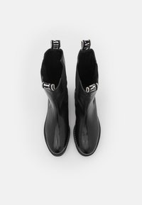 Black leather ankle boots with a smooth finish, round toes, and contrasting fabric pull tabs at the back. Flat soles complete the design.