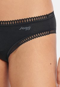 Zwarte katoen slip met kant langs de tailleband, voorzien van een logo aan de zijkant. Gladde textuur en een lage taille.