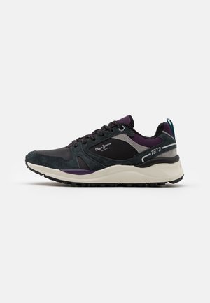Niedriger Sneaker mit schwarzen, dunkelgrünen und violetten Einsätzen, weißer Sohle, Schnürsenkeln und "Pepe Jeans"-Markierung an der Seite.