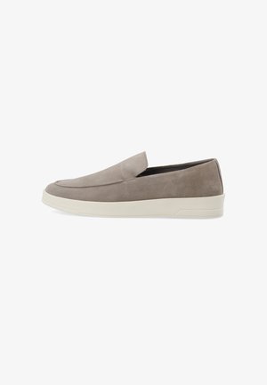Scarpe slip-on in suede grigio con suola piatta in gomma bianca, caratterizzate da un design semplice e una punta arrotondata con dettagli di cucitura minimi.