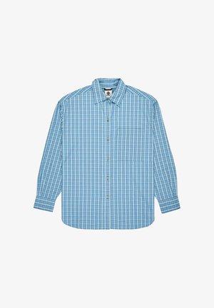 Lys blå skjorte med knappelukning, der har et ternet mønster i forskellige nuancer. Lange ærmer, enkelt brystlomme og buet kant.