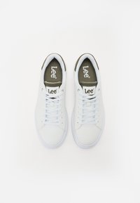 Hvite sneakers med en glatt overflate, prydet med hvite lisser, en teksturert olivengrønn hælhette og en merket ankelkledning.