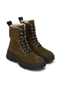 Brązowe zamszowe buty za kostkę z wiązaniem, z puszystym wnętrzem, czarnymi oczkami, grubymi czarnymi podeszwami i uchwytami na górze.