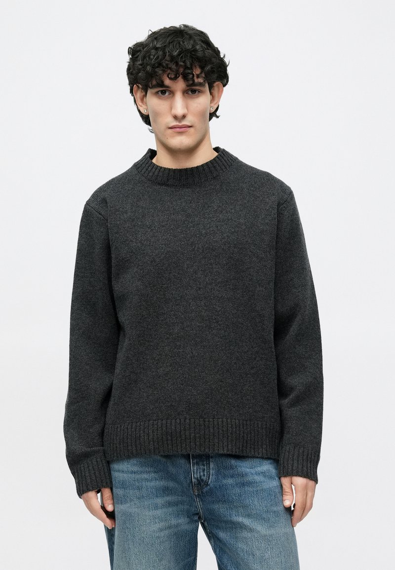 Pull gris foncé avec un col rond côtelé, manches longues et coupe décontractée. Confectionné en tissu texturé, avec poignets et ourlet côtelés.