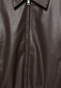Hnedá syntetická kožená bunda s rozpínacím zipsom, veľkým golierom a textúrovaným povrchom so popraskaným vzorom. Obsahuje bočné vrecká.