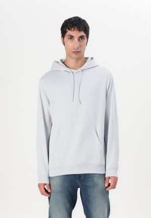 Lichtgrijze hoodie van zacht materiaal, met een voorkantzak, verstelbare trekkoord en een klein logopatch op de borst.