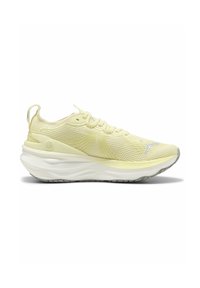 Botte de sport jaune clair avec une tige en mesh texturé, semelle blanche rembourrée et éléments réfléchissants sur le côté et la languette.