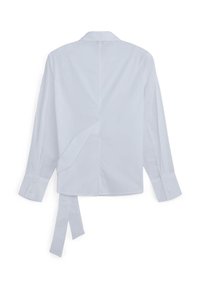 Camicia bianca a maniche lunghe con colletto, polsi abbottonati e una cintura di tessuto morbido che pende dalla schiena.