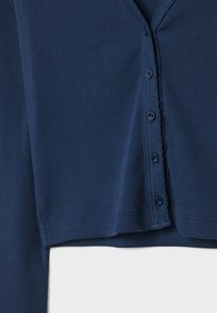 Donkerblauwe, geribbelde longsleeve met een V-hals en knoopsluiting. Kenmerkt zich door een zachte textuur en een aansluitend ontwerp.