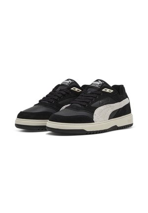 Paire de baskets Puma noir et blanc avec lacets noirs et semelles blanc cassé, affichées côte à côte sur un fond blanc.