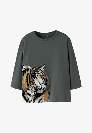 Grå bomulls-t-shirt med lös passform, med en stor tryckt tigermotiv i orange, svart och vitt på framsidan. Rund halsringning.