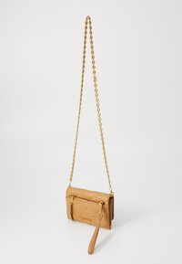 Tan quilted læder crossbody taske med en guldkæde-strop, lynlåslomme og en aftagelig håndledsstrop. Glat tekstur og kompakt form.