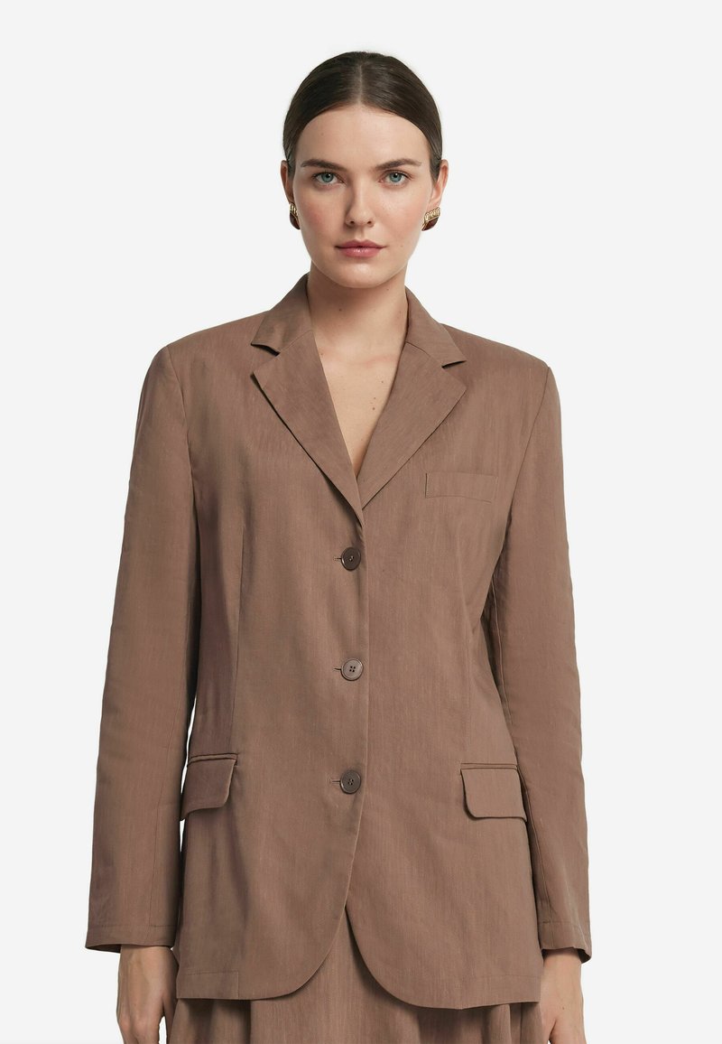 Brązowa, dopasowana marynarka z klapami, dwoma przednimi kieszeniami, trzema guzikami i lekką teksturą materiału. Prosty i nowoczesny design.