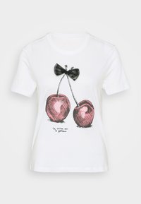 T-shirt en coton blanc avec un design de nœud noir et de cerises roses avec des contours noirs. Le texte ci-dessous dit "la cerise sur le gâteau."