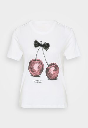 T-shirt bianco in cotone con un disegno di un fiocco nero e ciliegie rosa con contorni neri. Il testo sottostante recita "la cerise sur le gâteau."