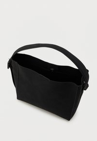 Sort rektangulær håndtaske med en bred rem, åben top med trykknaplukning og en synlig indvendig lomme på hvid baggrund.