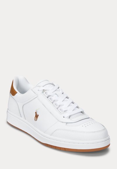 Bela usnjena teniska z teksturiranim petnim poudarkom v tan barvi. Ima perforirano konico, bele vezalke in majhen vezen logotip ob strani.