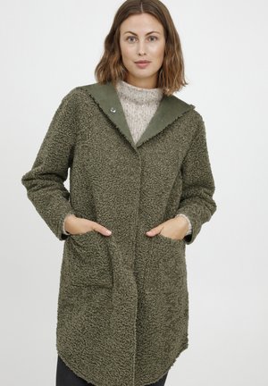 Svetle olivově zelený fleece kabát s texturovaným povrchem, oversized límcem a dvěma předními kapsami. Zapínání na stříbrný knoflík na krku.