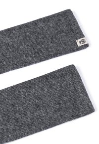 Dark gray knitted fabric headband with a small beige label featuring a black logo on a white background.