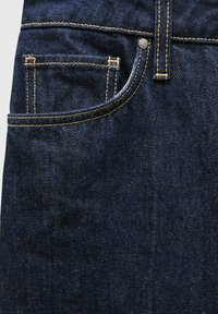 Donkerblauwe denim jeans met een voorzak, contrasterende oranje stiksels en een metalen knoopdetail. Gladde textuur met een klassiek ontwerp.