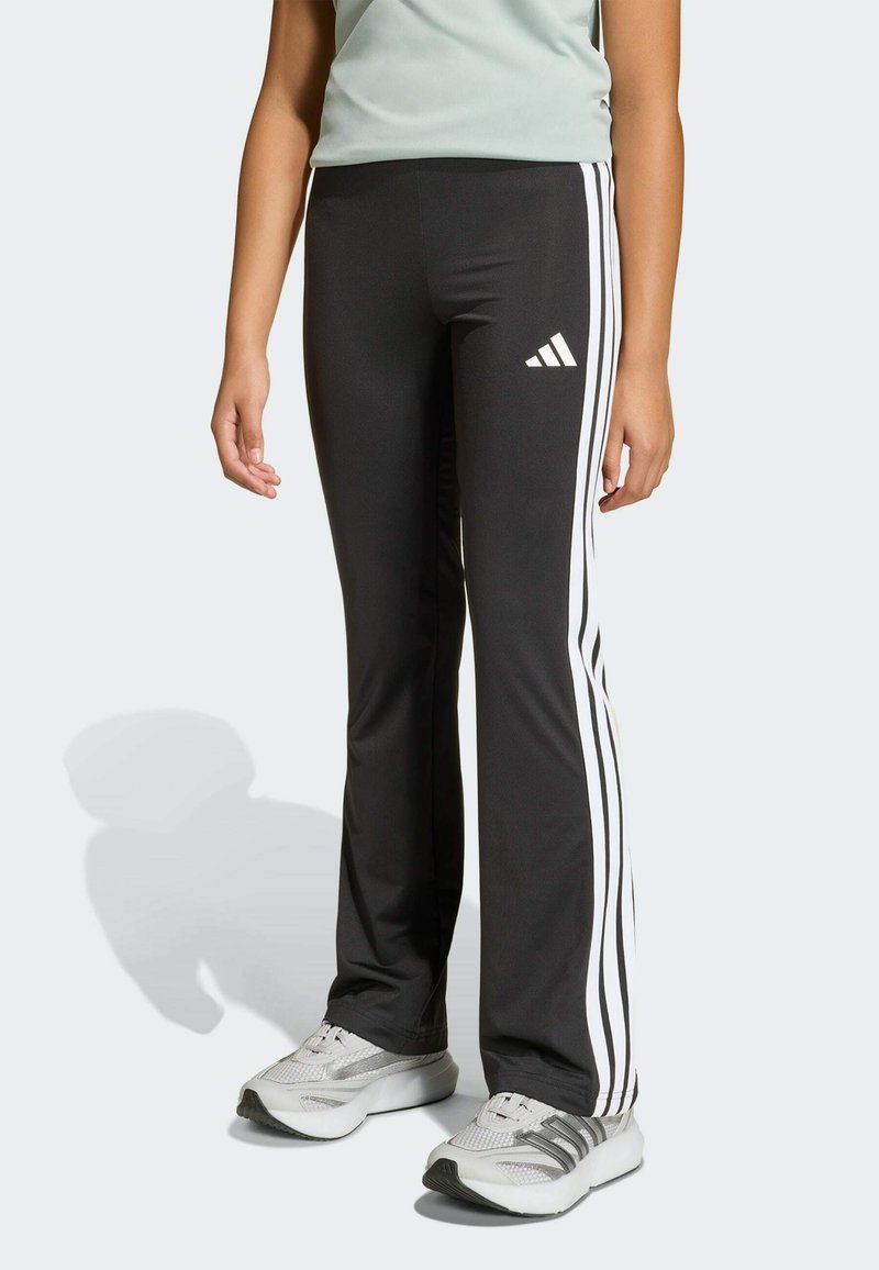 Crne atletske hlače s bijelim bočnim prugama, izrađene od rastezljivog materijala, s Adidas logotipom na lijevom bedru. Slim fit dizajn.