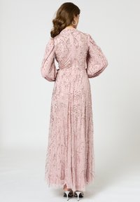Langes pinkes Kleid mit bestickten Perlenmustern, mit Puffärmel und taillierter Körper. Glatte Textur, bodenlanger Schnitt, Rückansicht.