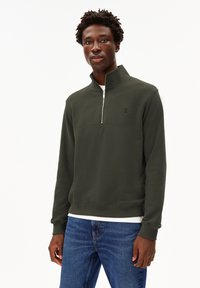 Dunkelgrüner Reißverschluss-Sweatshirt mit hohem Kragen, ausgestattet mit einer weißen Innenschicht und einem dezenten Logo auf der Brust. Glatte Textur, lässige Passform.