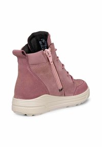 Vaaleanpunaiset mokkanahkasaappaat nilkkapituisina, joissa on edessä vetoketju, pyöreä kärki, tekstuuripinnoitteinen kangasvuori ja valkoinen kumipohja, jossa on pito kuvioita.