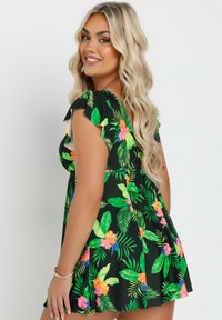 Vestido negro con estampado floral tropical en verde, rosa y naranja. Presenta mangas con volantes y una silueta acampanada. Textura de tela suave.