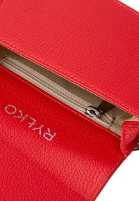Borsa in pelle rossa con texture, chiusura con zip liscia, foderata in beige e dettaglio logo in argento.