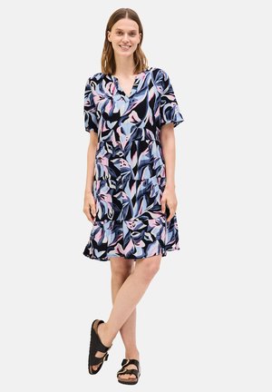 Blumenmusterkleid mit navyblauem Hintergrund, kurzen Ärmeln, V-Ausschnitt und gestuften Rockdesign. Getragen mit schwarzen Sandalen.