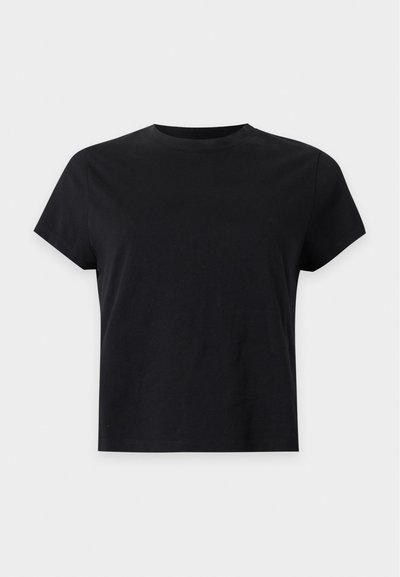 Απλό μαύρο κοντομάνικο μπλουζάκι με στρογγυλή λαιμόκοψη και ίσια γραμμή, παρουσιασμένο σε ανοιχτό γκρι φόντο.